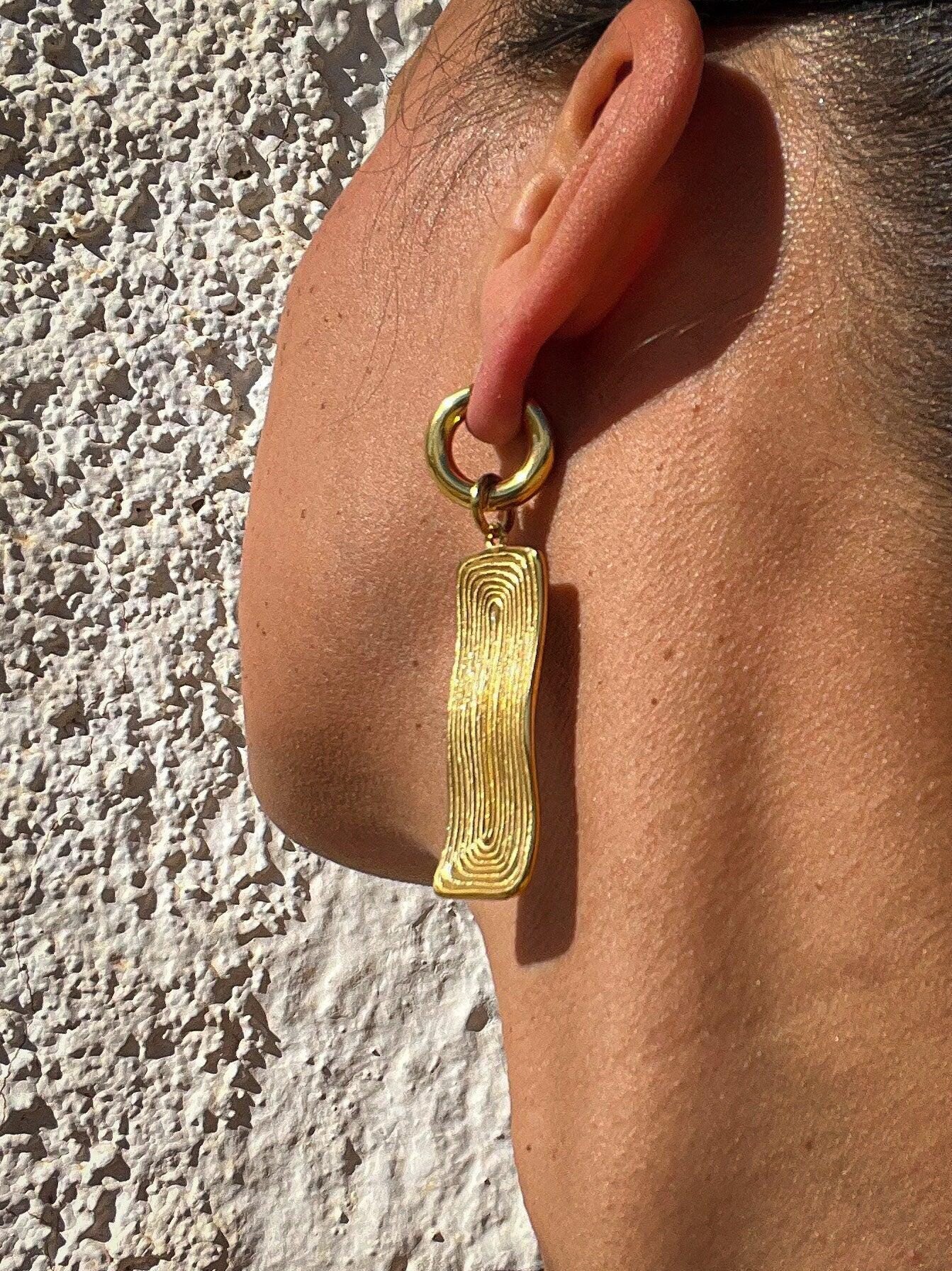Große goldene hängende Ohrringe